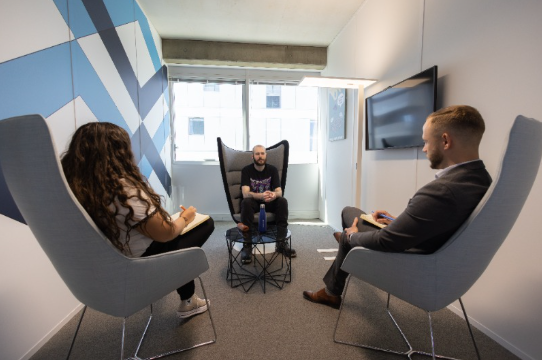 Collaborateurs en train de discuter dans des fauteuils