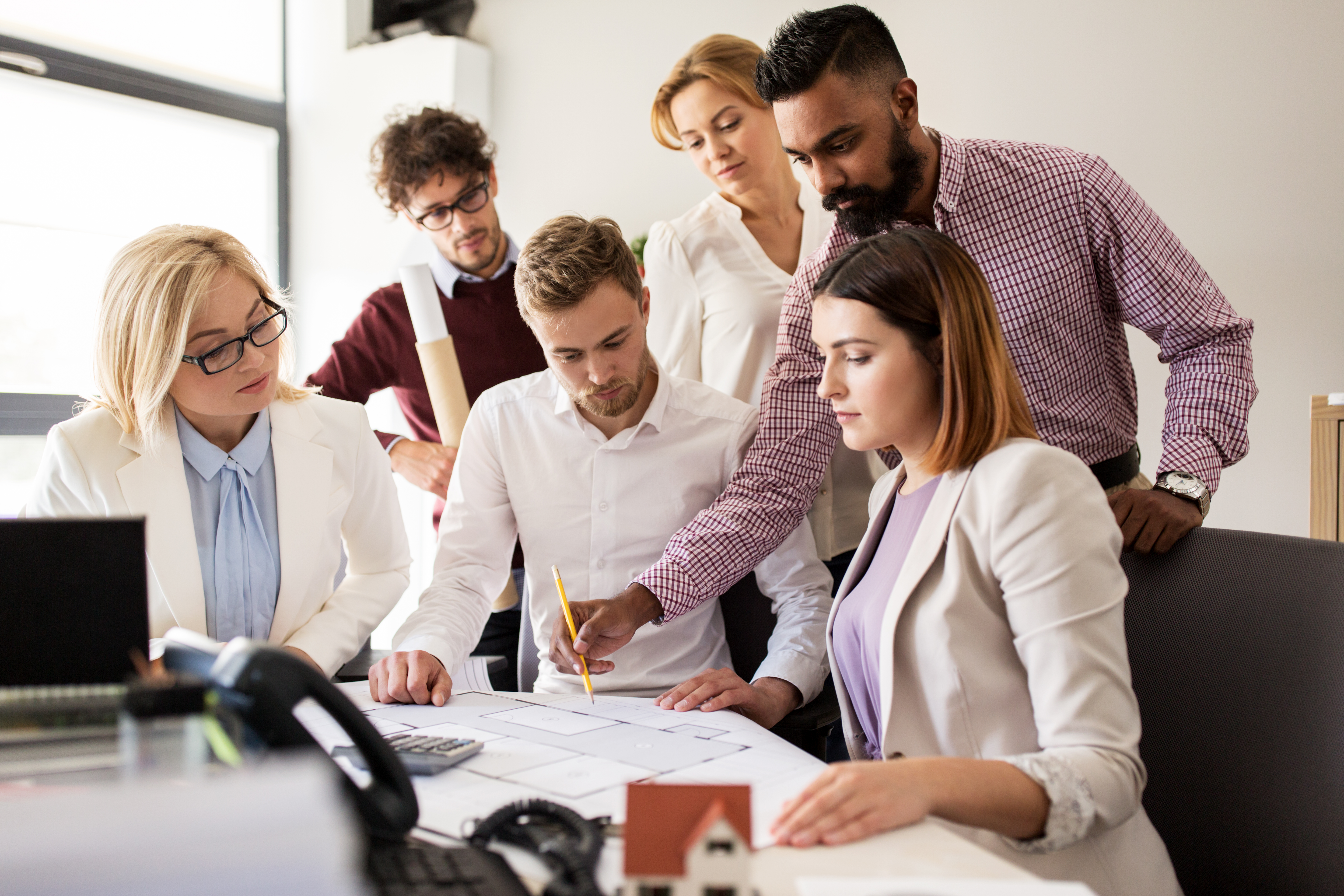 business-team-discussing-house-project-at-office-P9S5Z8M_0