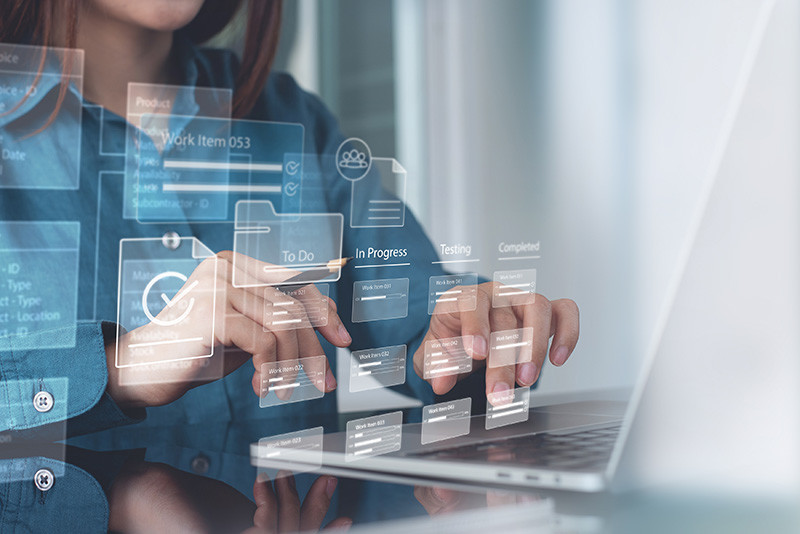 Personne utilisant un gestionnaire de projet d'entreprise sur ordinateur portable.